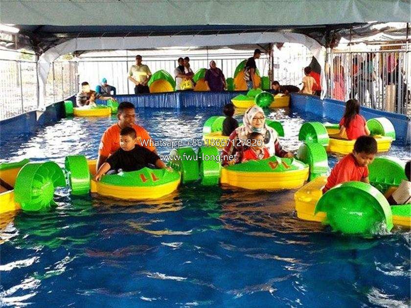 Full overall view of kids pedal paddle boat on pool water surface (1).jpg