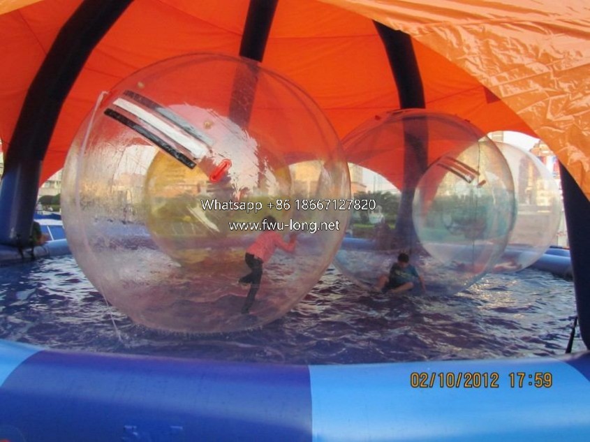 Kids and adults playing water walking ball on swimming pool water.JPG