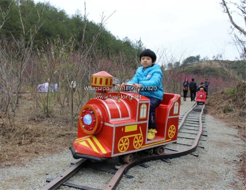 Kids riding mini track train at indoor mall playground scene.jpg